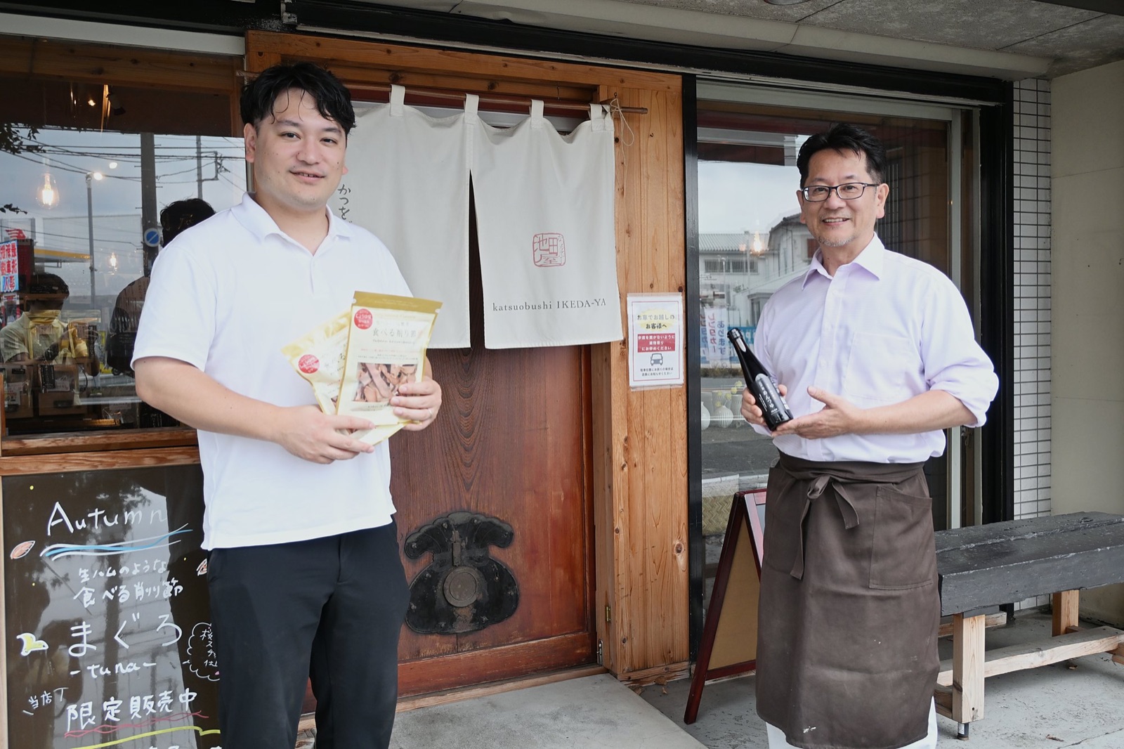 店の前に立つ池田専務（左）と池田社長（右）