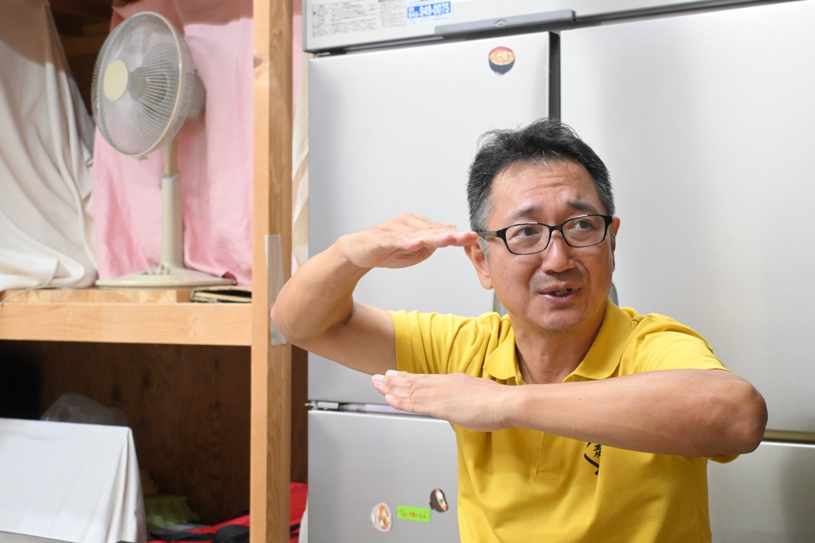 麹菌が元気に育つ温度帯を、手で示す小泉さん