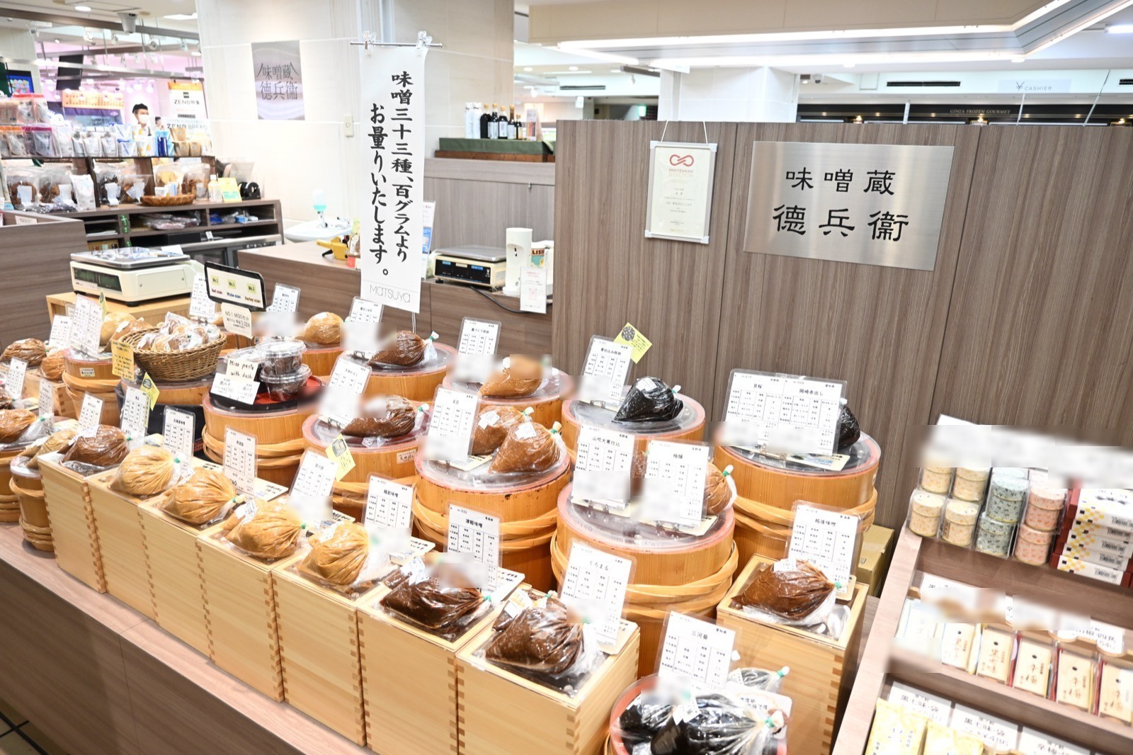 木桶と商品カードが並ぶ、味噌蔵德兵衞の売り場